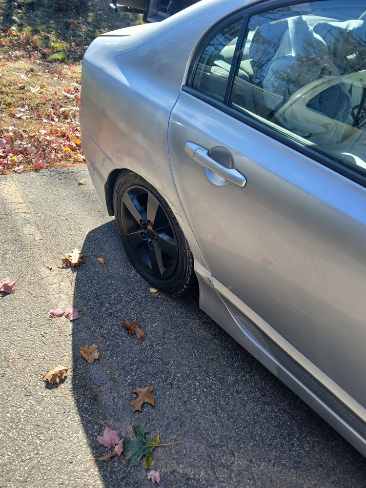 Silver Honda Civic showing rear quarter damage